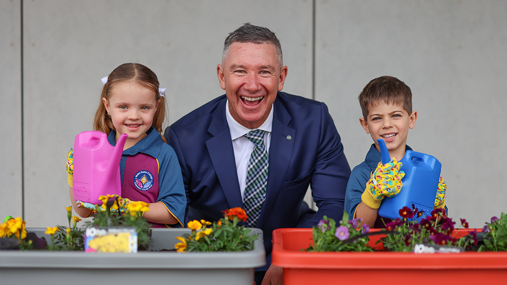 Principal beside two students in an outdoor learning location