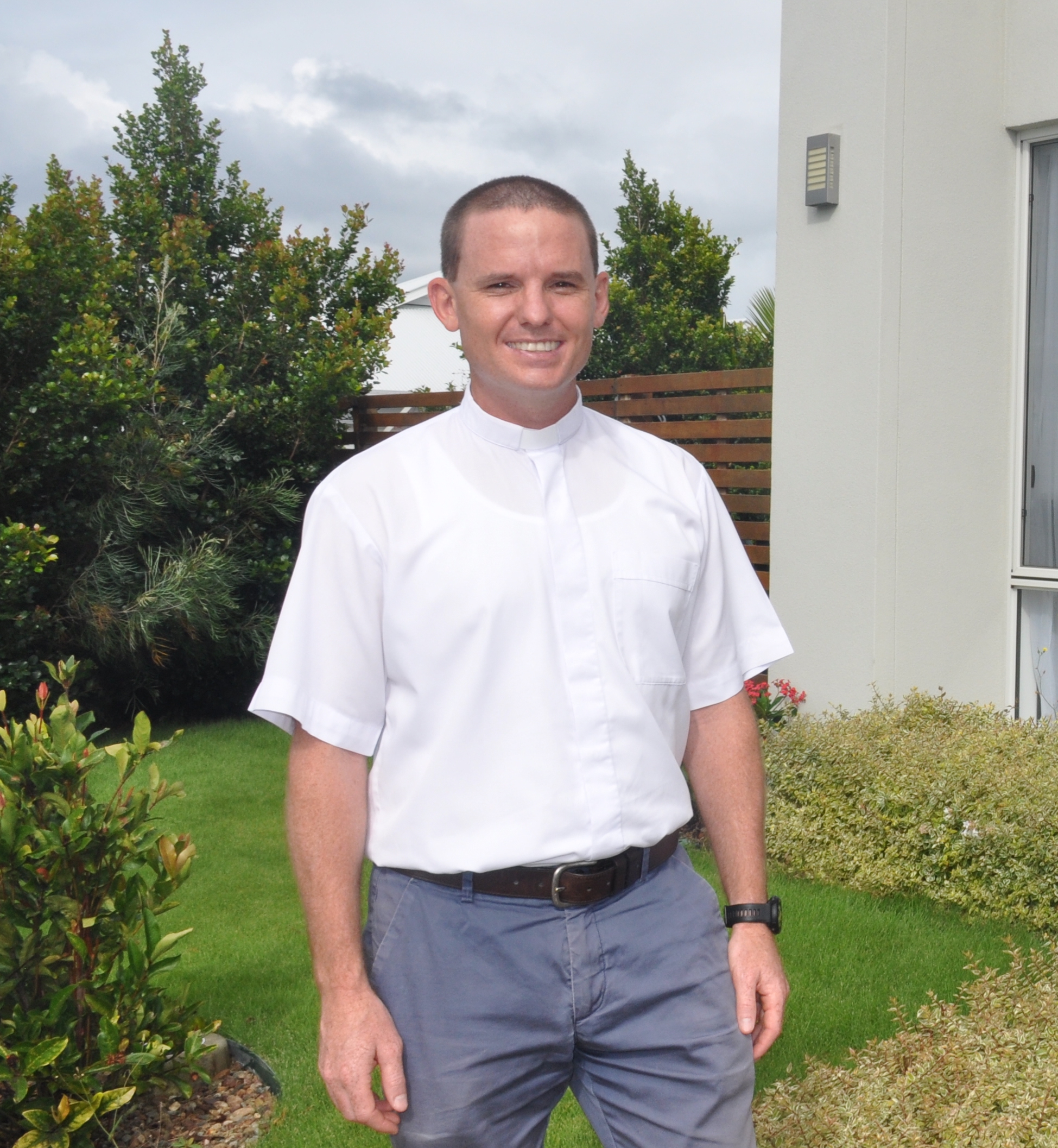 Catholic Parish Priest, Fr Joshua Whitehead, stands in an outdoor setting